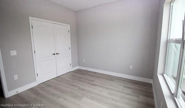 unfurnished bedroom with a closet and light hardwood / wood-style flooring