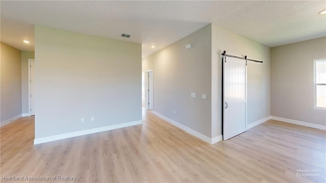 3900 Monza Dr, Sebring, FL 33872 - spare room featuring light wood-style floors, baseboards, a barn door, and visible vents