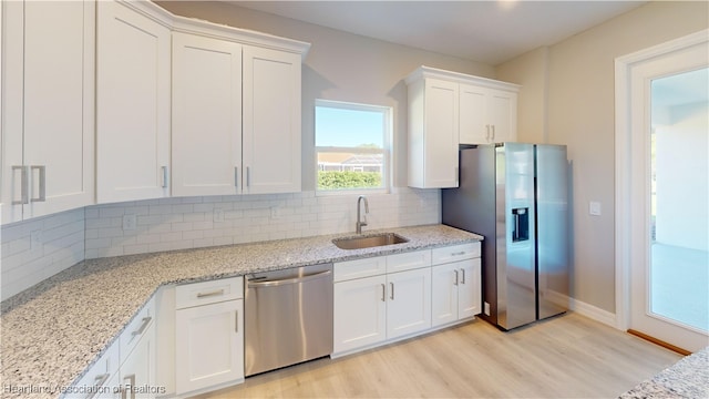 3900 Monza Dr, Sebring, FL 33872 - kitchen with a sink, tasteful backsplash, light wood-type flooring, stainless steel appliances, and white cabinets