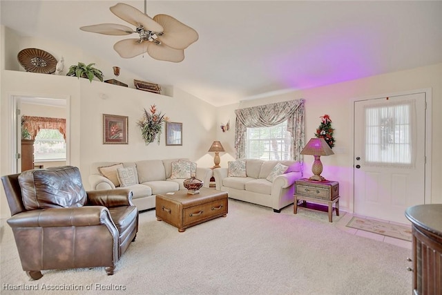 carpeted living room with ceiling fan and lofted ceiling