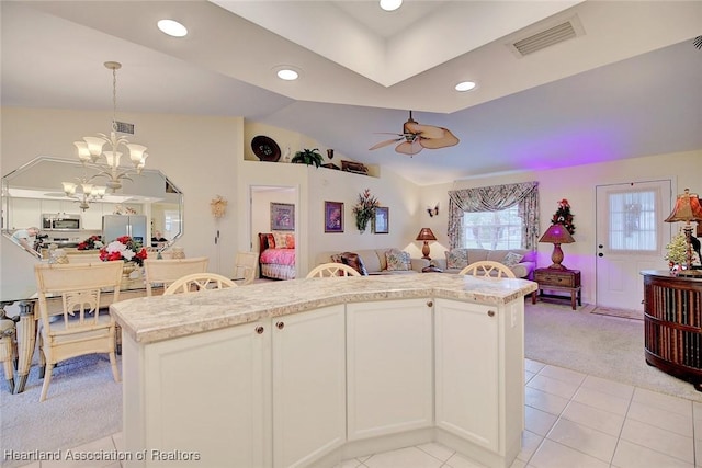 kitchen featuring white refrigerator with ice dispenser, white cabinets, ceiling fan with notable chandelier, decorative light fixtures, and light colored carpet