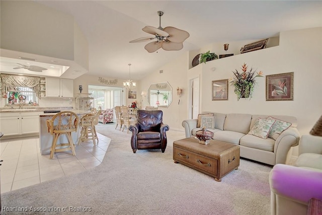 living room with ceiling fan with notable chandelier, light tile patterned floors, sink, and high vaulted ceiling