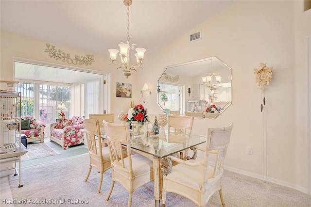 carpeted dining area featuring vaulted ceiling and an inviting chandelier