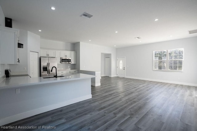 kitchen with white cabinets, sink, stainless steel appliances, and hardwood / wood-style floors