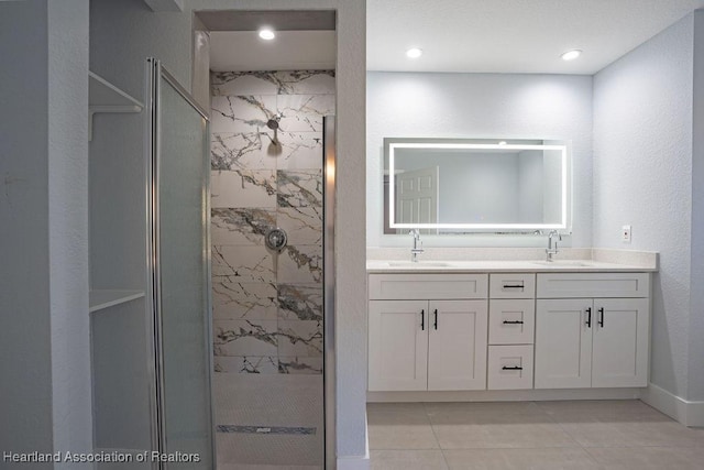 bathroom featuring tiled shower, vanity, and tile patterned floors