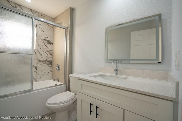 full bathroom featuring combined bath / shower with glass door, vanity, and toilet