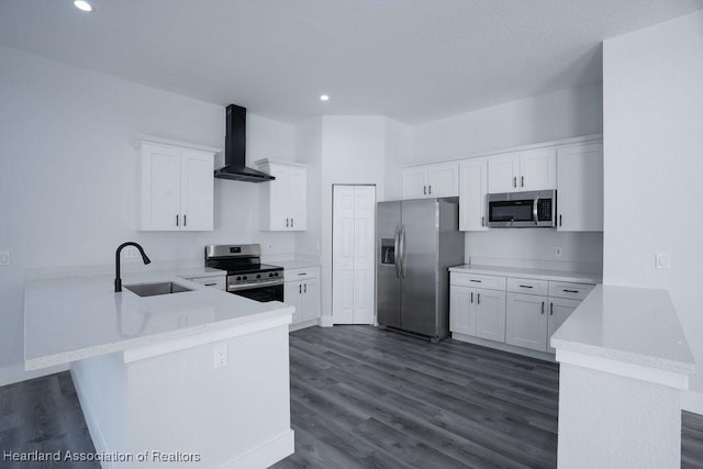 kitchen featuring kitchen peninsula, white cabinetry, wall chimney range hood, and appliances with stainless steel finishes