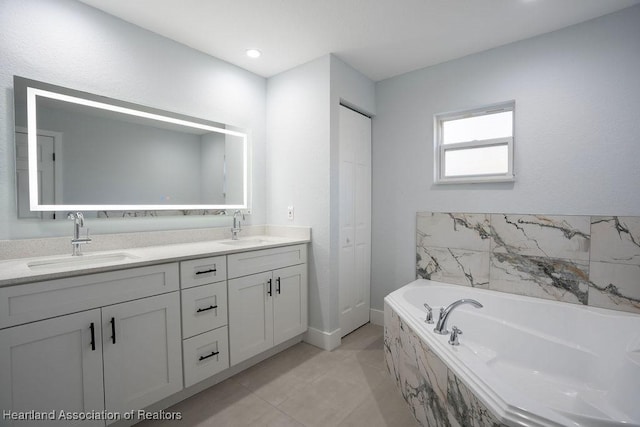 bathroom featuring tile patterned flooring, vanity, and tiled bath