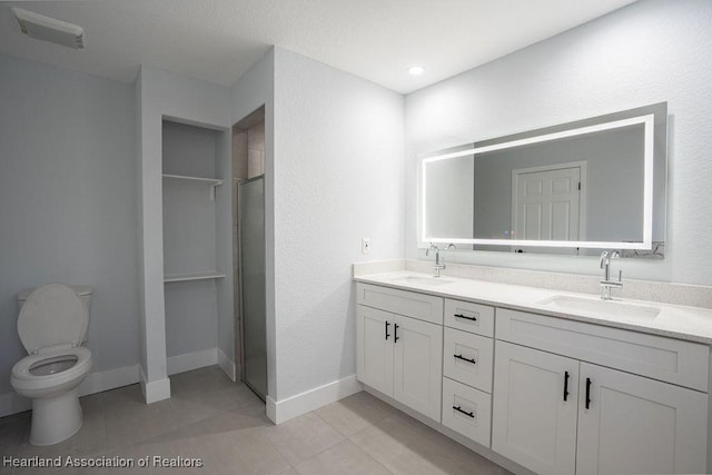 bathroom with tile patterned flooring, vanity, toilet, and a shower with door