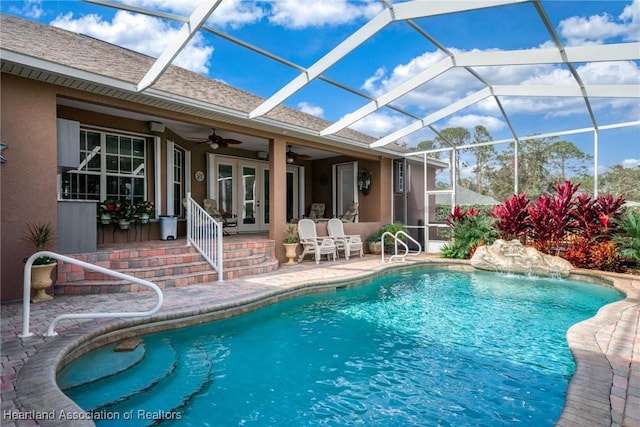 view of swimming pool with pool water feature, ceiling fan, a patio area, and glass enclosure