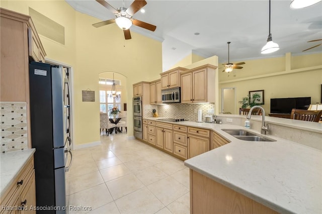 kitchen with light brown cabinetry, sink, pendant lighting, stainless steel appliances, and decorative backsplash