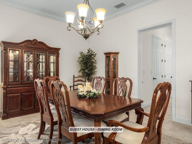 dining space with a notable chandelier, ornamental molding, and light hardwood / wood-style floors