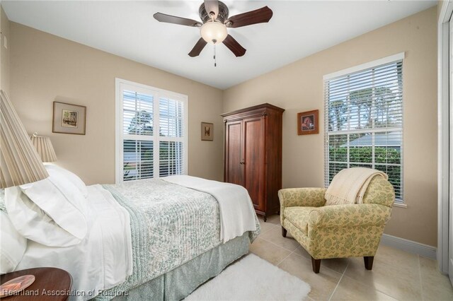 tiled bedroom featuring ceiling fan