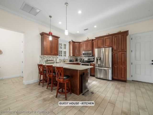 kitchen featuring kitchen peninsula, stainless steel appliances, decorative light fixtures, a breakfast bar area, and decorative backsplash