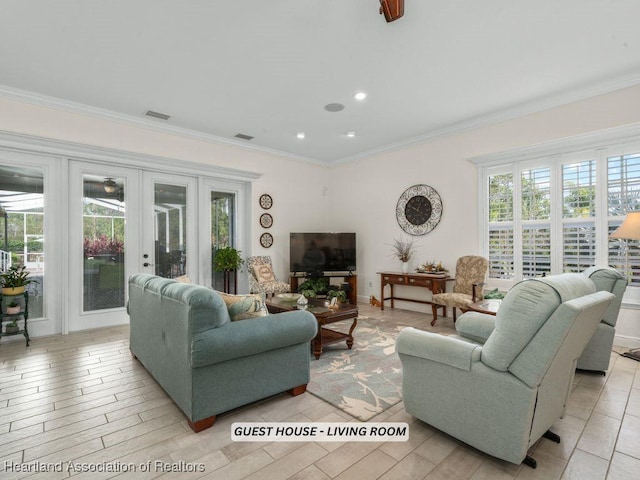 living room with plenty of natural light, french doors, and ornamental molding