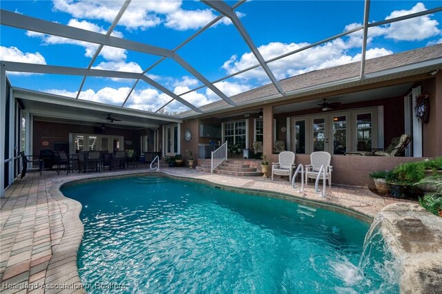 view of swimming pool with ceiling fan, a patio, french doors, and pool water feature