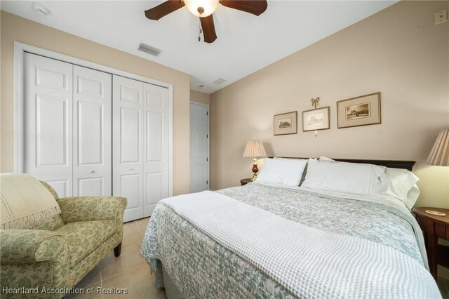 tiled bedroom featuring ceiling fan and a closet