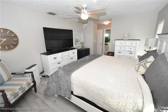 bedroom featuring a ceiling fan, visible vents, and light wood-type flooring