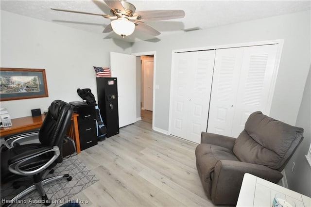 office featuring light wood-type flooring, visible vents, and ceiling fan