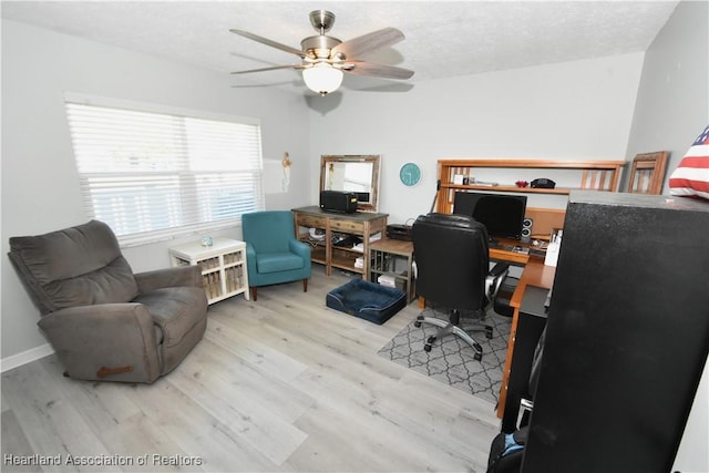 home office with a textured ceiling, baseboards, a ceiling fan, and wood finished floors