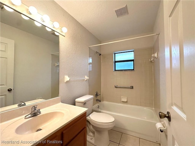 full bathroom with tile patterned floors, vanity, a textured ceiling, toilet, and tiled shower / bath