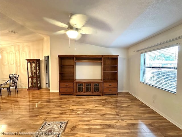 living room featuring ceiling fan, wood-type flooring, a textured ceiling, and vaulted ceiling