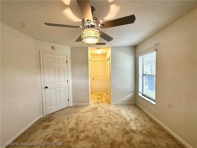 carpeted spare room featuring ceiling fan