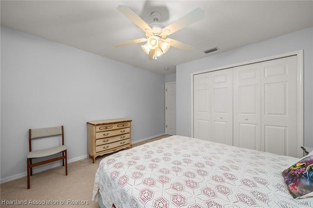 bedroom with visible vents, baseboards, ceiling fan, a closet, and light colored carpet