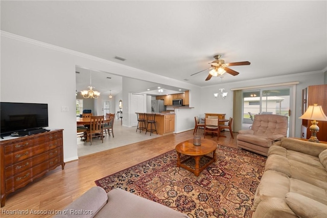 living room with baseboards, light wood-style floors, ornamental molding, and ceiling fan with notable chandelier