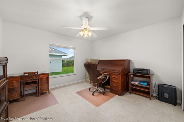 carpeted home office featuring baseboards and a ceiling fan