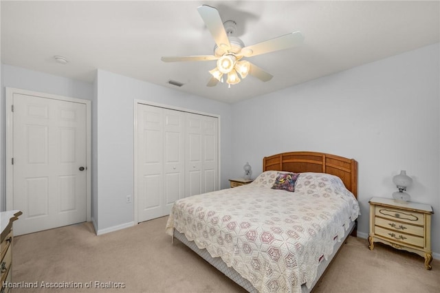 bedroom with visible vents, baseboards, ceiling fan, light carpet, and a closet