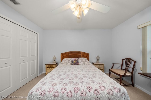 bedroom with a closet, visible vents, light colored carpet, and baseboards