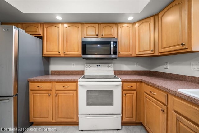 kitchen with dark countertops, recessed lighting, and stainless steel appliances