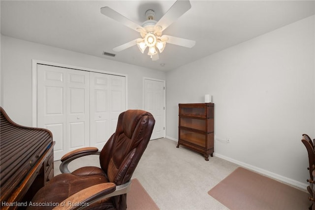 office featuring visible vents, baseboards, light colored carpet, and a ceiling fan