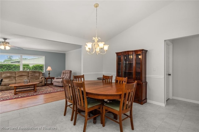 dining room featuring ceiling fan with notable chandelier, baseboards, and vaulted ceiling