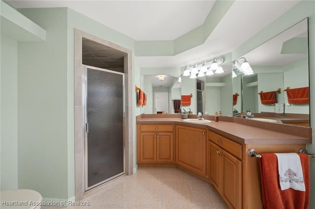 full bath featuring toilet, a stall shower, vanity, and tile patterned flooring