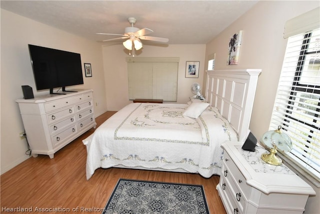 bedroom with ceiling fan, light wood-type flooring, and multiple windows