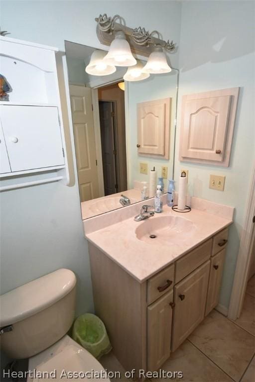 bathroom with tile patterned flooring, vanity, and toilet