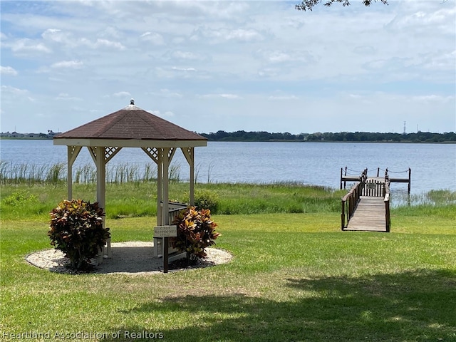 exterior space with a gazebo, a yard, a water view, and a boat dock