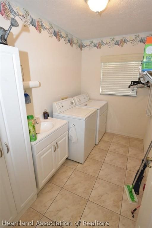 washroom with cabinets, independent washer and dryer, sink, and light tile patterned floors