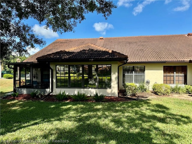 back of house featuring a sunroom and a yard