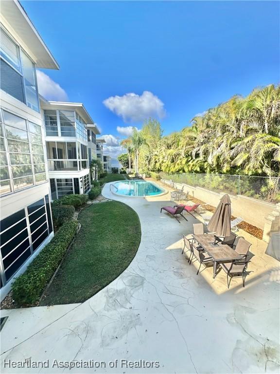 view of home's community featuring a patio area, fence, and a swimming pool