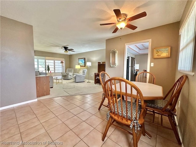 dining space featuring light tile patterned flooring, ceiling fan, and baseboards