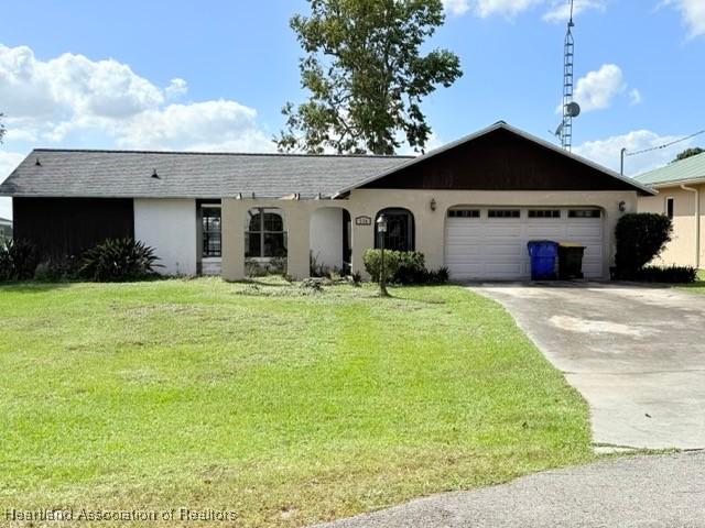 ranch-style home with a front yard and a garage