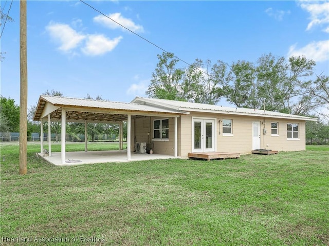 back of house with a patio, a lawn, and french doors