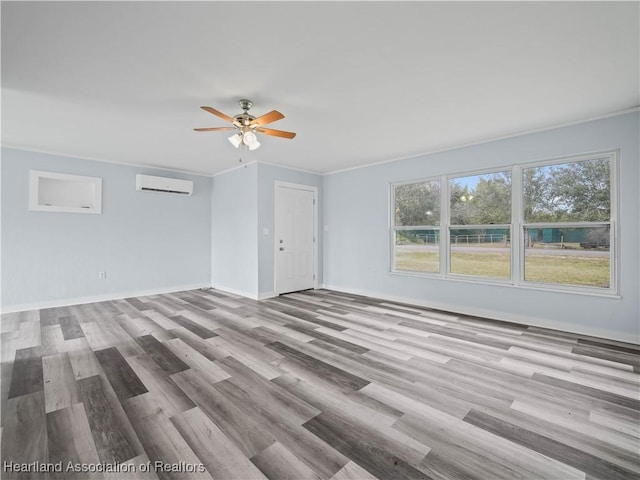 empty room featuring crown molding, ceiling fan, light hardwood / wood-style floors, and a wall unit AC