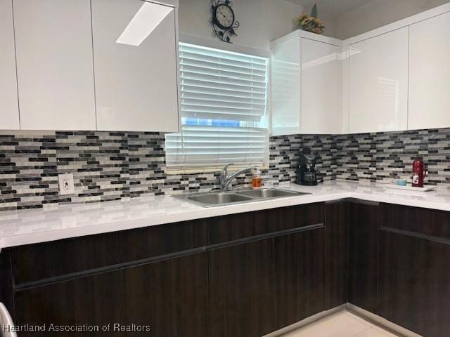 9590 NW 22nd Ave, Miami, FL 33147 - kitchen featuring dark brown cabinetry, decorative backsplash, modern cabinets, white cabinetry, and a sink