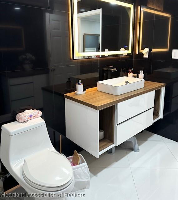 9590 NW 22nd Ave, Miami, FL 33147 - bathroom featuring toilet, tile patterned flooring, decorative backsplash, and vanity