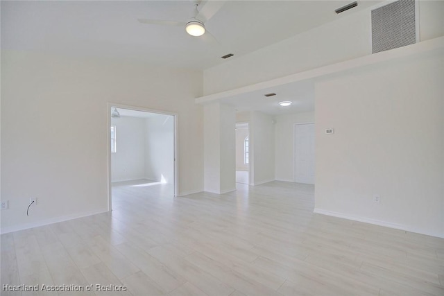 empty room featuring ceiling fan, a wealth of natural light, and light hardwood / wood-style floors