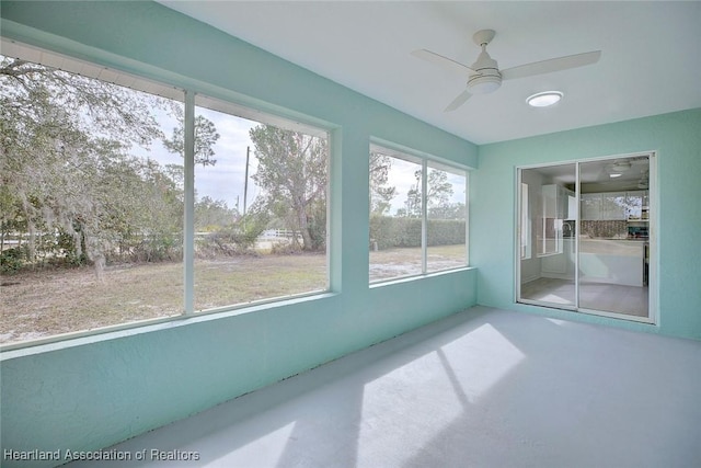 unfurnished sunroom featuring ceiling fan